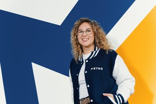 a lady standing in front of METRO logo